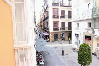 a street with umbrellas in a city with buildings at Apartamento GRACIA by Cadiz4Rentals in Cádiz