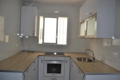 a kitchen with white cabinets and a sink and a window at Beautiful Central Cadiz in Cádiz