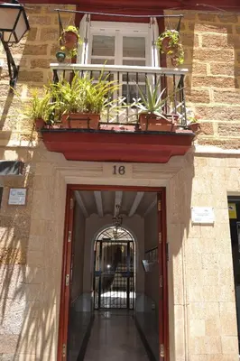 a door to a building with a balcony with plants at Beautiful Central Cadiz in Cádiz