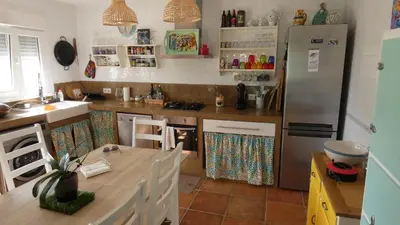 a kitchen with a table and a refrigerator at Villa Lolo de design con Piscina, Jardin y Parking exclusivo in Chiclana de la Frontera