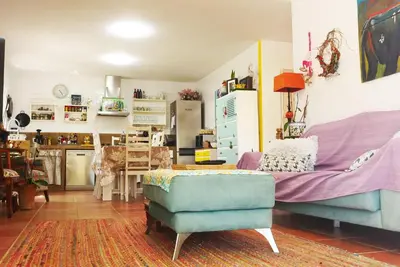 a living room with a blue couch and a kitchen at Villa Lolo de design con Piscina, Jardin y Parking exclusivo in Chiclana de la Frontera
