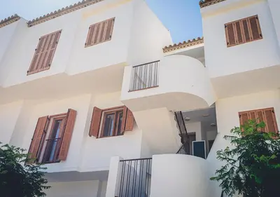 an external view of a white building with balconies at Apartamentos Turísticos La Carrajolilla in Chiclana de la Frontera