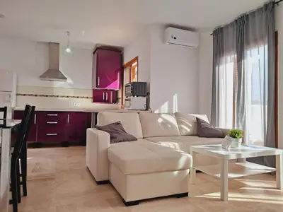 a living room with a white couch and a table at Apartamentos Turísticos La Carrajolilla in Chiclana de la Frontera