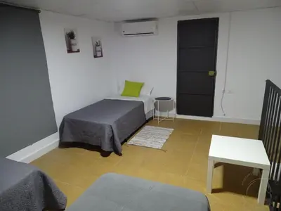 a room with two beds and a staircase with a stair case at Casasjerezanas VistaFlor in Jerez de la Frontera