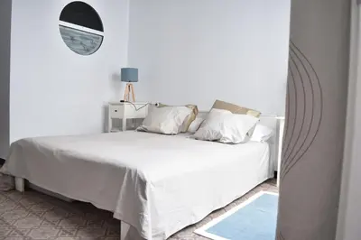 a bedroom with a white bed and a mirror at Veedor 12 in Cádiz