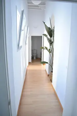 a hallway with white walls and a wooden floor at Veedor 12 in Cádiz