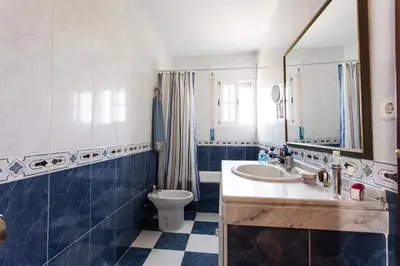 a bathroom with a sink and a toilet and a mirror at Dunas villa in El Puerto de Santa María