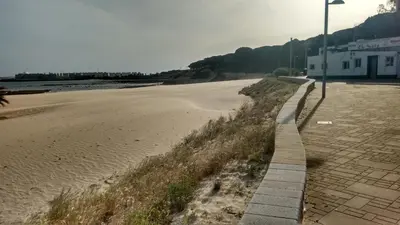 a sidewalk next to a beach with a street light at Dunas villa in El Puerto de Santa María
