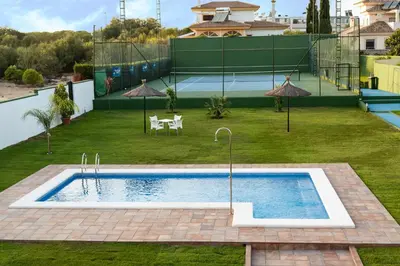 a swimming pool in the middle of a yard at Dunas villa in El Puerto de Santa María