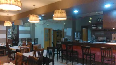 a restaurant with tables and chairs and a bar at Hotel Las Canteras de Puerto Real in Puerto Real