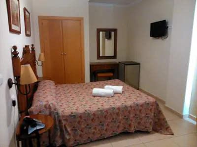 a bedroom with a bed with two towels on it at Hotel Las Canteras de Puerto Real in Puerto Real