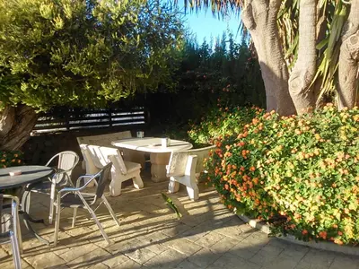 a patio with a table and chairs and some flowers at Hotel Las Canteras de Puerto Real in Puerto Real