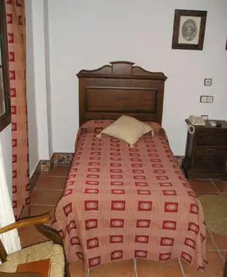 a bedroom with a bed with a red comforter at El Perro de Paterna in Paterna de Rivera