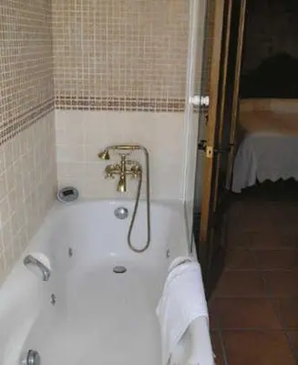 a bath tub in a bathroom with a towel at El Perro de Paterna in Paterna de Rivera