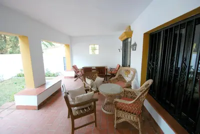 a room with chairs and a table on a balcony at Oasis en la playa in Chiclana de la Frontera