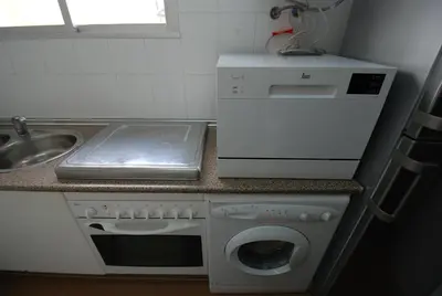 a kitchen with a washing machine and a sink at Oasis en la playa in Chiclana de la Frontera