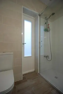 a bathroom with a shower and a white toilet at Oasis en la playa in Chiclana de la Frontera