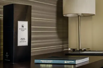 a stack of books sitting on a table next to a lamp at Eurostars Asta Regia Jerez in Jerez de la Frontera
