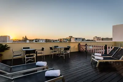 a rooftop deck with tables and chairs on a building at Eurostars Asta Regia Jerez in Jerez de la Frontera