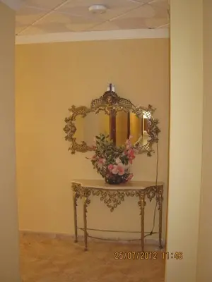 a dressing table with a mirror and flowers on it at Hotel Caballo Negro in Puerto Real