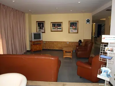 a living room with leather furniture and a tv at Hotel Caballo Negro in Puerto Real
