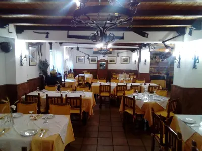 a dining room with white tables and yellow chairs at Hotel Restaurante Calderon in Arcos de la Frontera