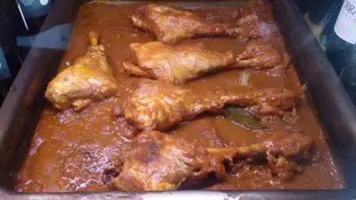 a tray of food with chicken in a sauce at Hotel Restaurante Calderon in Arcos de la Frontera