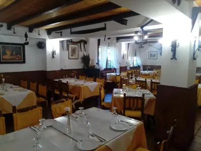 a dining room with tables and chairs in a restaurant at Hotel Restaurante Calderon in Arcos de la Frontera