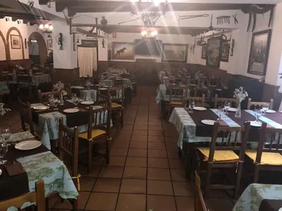 a restaurant with tables and chairs and a room filled with tables at Hotel Restaurante Calderon in Arcos de la Frontera
