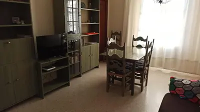a living room with a table and chairs and a television at Atardeceres Sureños - Gran Terraza - Parking in Jerez de la Frontera