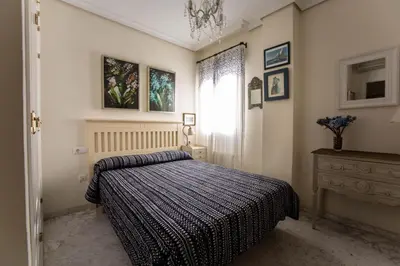 a bedroom with a bed and a window and a dresser at La Terraza del Drago in Cádiz