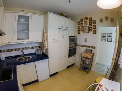 a kitchen with white cabinets and a sink at La Terraza del Drago in Cádiz