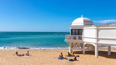 a group of people on a beach with a building at CDZ - Poniente in Cádiz