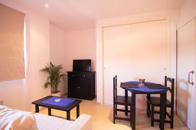 a living room with two tables and a tv at Apartamento Racimo El Puerto de Santa Maria in El Puerto de Santa María