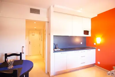 a kitchen with white cabinets and a table in a room at Apartamento Racimo El Puerto de Santa Maria in El Puerto de Santa María