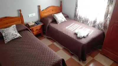 a bedroom with two beds and a window at Hostal Andalucia de Arcos in Arcos de la Frontera