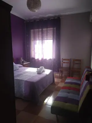 a bedroom with a bed and a window and a chair at Hostal Andalucia de Arcos in Arcos de la Frontera