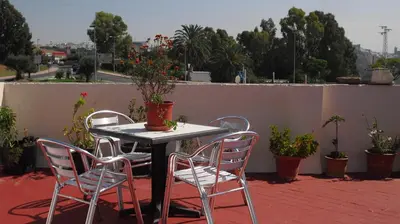 a table and chairs on a patio with plants at Hostal Andalucia de Arcos in Arcos de la Frontera