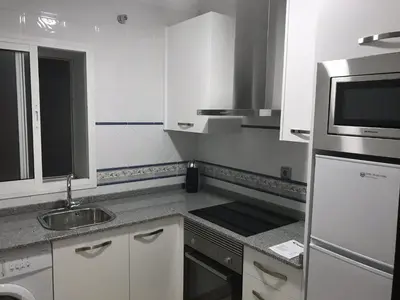 a white kitchen with a sink and a microwave at Rincón en el Mentidero in Cádiz