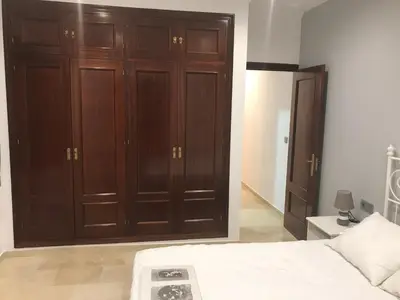 a bedroom with brown wooden cabinets and a bed at Rincón en el Mentidero in Cádiz