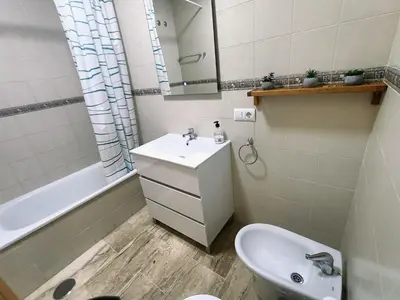 a bathroom with a sink and a toilet and a mirror at COSTA EL CASTILLO Apartamento con WIFI in Chiclana de la Frontera
