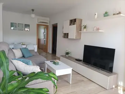 a living room with a couch and a flat screen tv at COSTA EL CASTILLO Apartamento con WIFI in Chiclana de la Frontera
