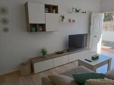 a living room with a tv on a white wall at COSTA EL CASTILLO Apartamento con WIFI in Chiclana de la Frontera