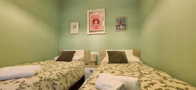 two beds in a room with green walls at Levante by Gades Gestión in Cádiz