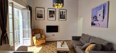 a living room with a couch and a tv at Levante by Gades Gestión in Cádiz