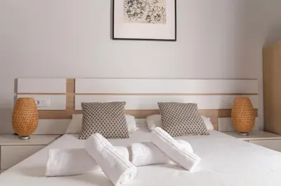 a white bed with four pillows on it at Levante by Gades Gestión in Cádiz
