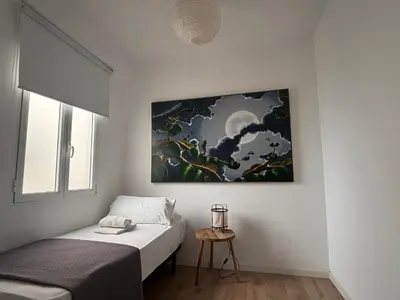 a room with two beds and a painting on the wall at FARO Family Home by Cadiz4Rentals in Cádiz