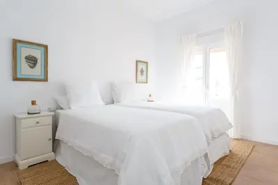 a white bedroom with a white bed and a window at FARO Family Home by Cadiz4Rentals in Cádiz