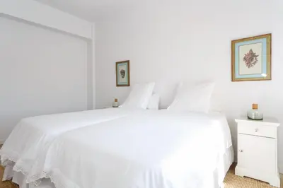 a white bedroom with a white bed and a white dresser at FARO Family Home by Cadiz4Rentals in Cádiz