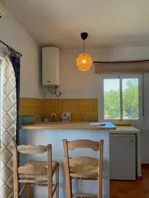 a kitchen with two chairs and a counter top at bungalow entre mer et montagne in Arcos de la Frontera